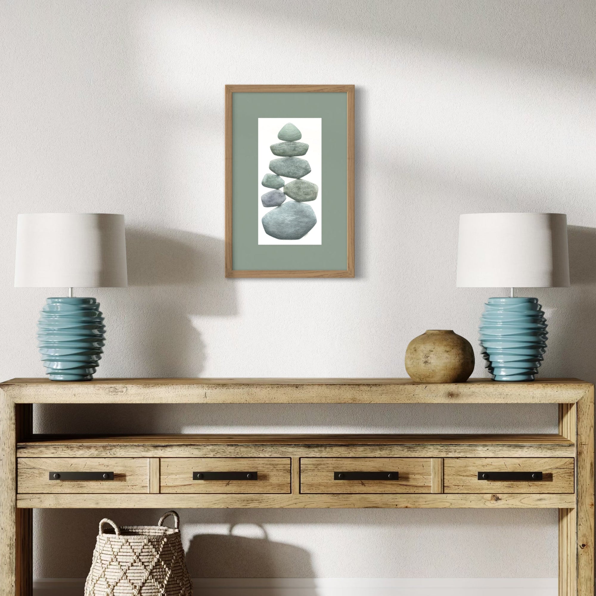 Wooden console table with two lamps, a basket, and a framed artwork on a white wall.