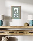 Wooden console table with two lamps, a basket, and a framed artwork on a white wall.