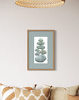 Framed artwork of stacked stones on a wall above a sofa with patterned cushions.