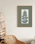 Living room with wicker chair, surfboard art, and framed pebble picture.