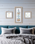 Bedroom with teal headboard, gray bedding, and framed artwork of watercolor leaves on a wooden wall.